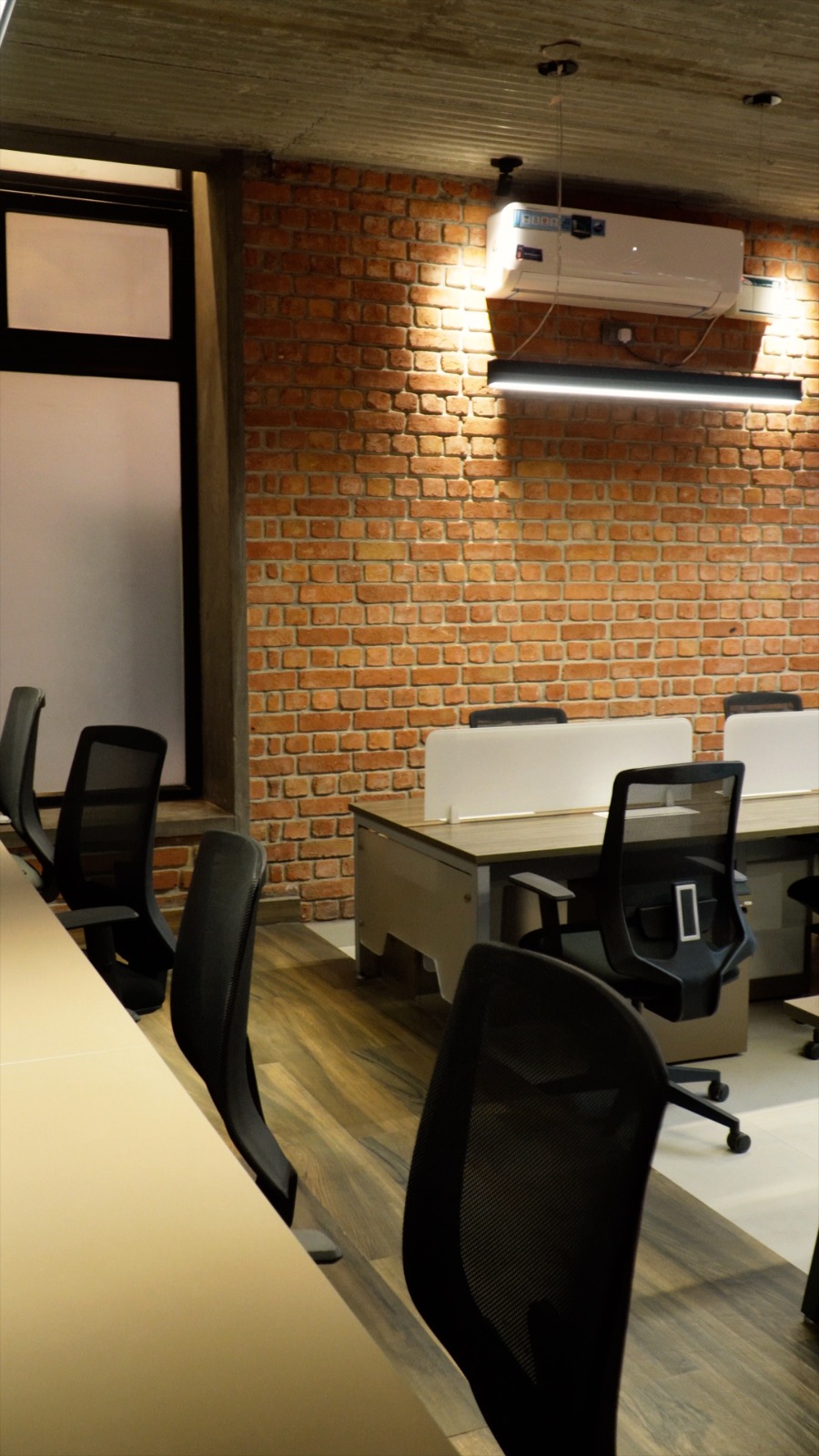 Travelopia workspace — brick wall office with workstations