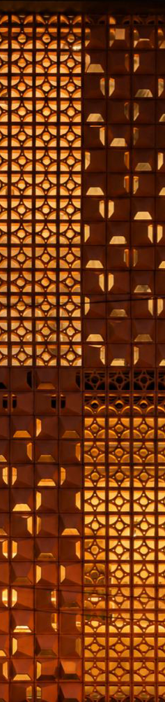 Terracotta architectural screen with geometric lattice and faceted tile patterns