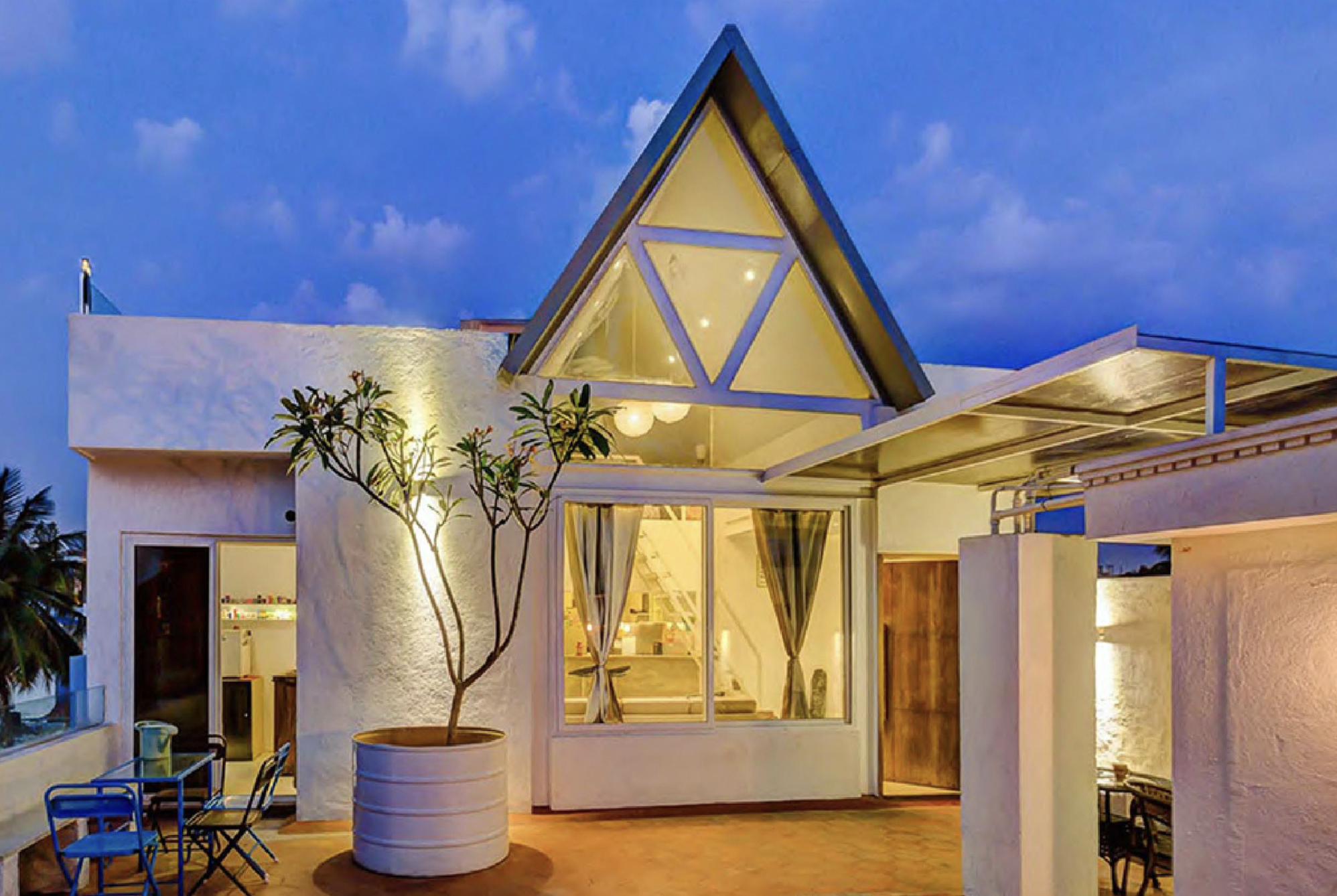 Contemporary home at dusk with triangular glass gable